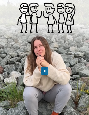 Junge Frau in Pullover und Jeans sitzt auf Steinen an der Küste und spricht in ein Mikro. Screenshot aus einem Reel.