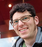 Sören ist einer von drei Peer-Berater*innen der BVSS Portraitfoto eines Mannes im mittleren Alter, dunkle, lockige Haare, mit Brille